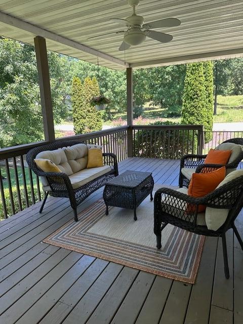 wooden terrace featuring ceiling fan and an outdoor hangout area