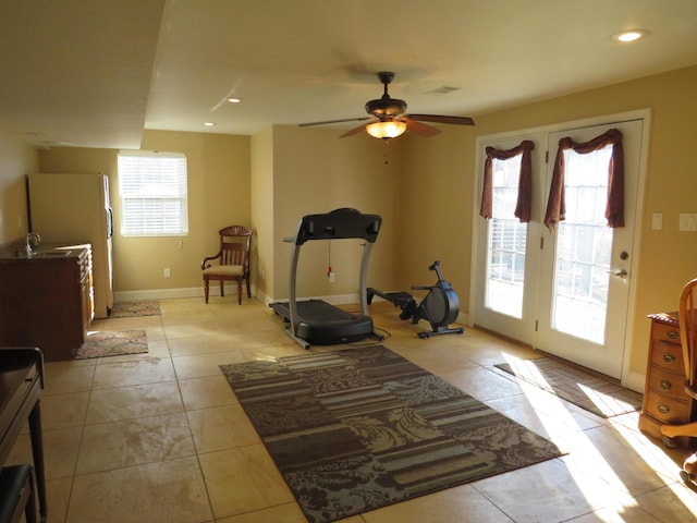 exercise area with light tile patterned flooring and ceiling fan