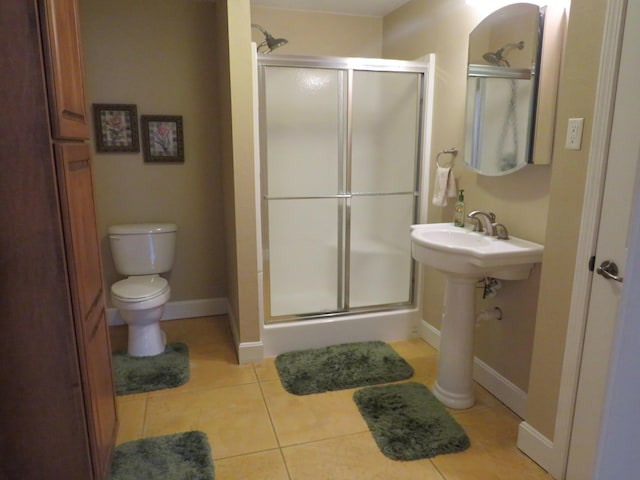 bathroom featuring tile patterned floors, a shower with door, and toilet