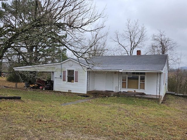 view of front of house featuring a carport, a front lawn, and covered porch