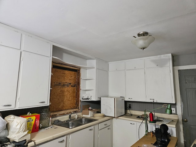 kitchen featuring white cabinetry and sink