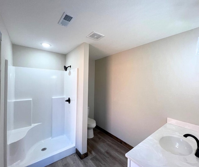 bathroom featuring wood finished floors, visible vents, a shower, and toilet