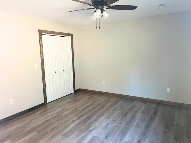 empty room with visible vents, baseboards, wood finished floors, and ceiling fan