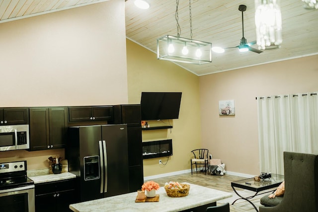 kitchen with baseboards, lofted ceiling, wood finished floors, stainless steel appliances, and pendant lighting