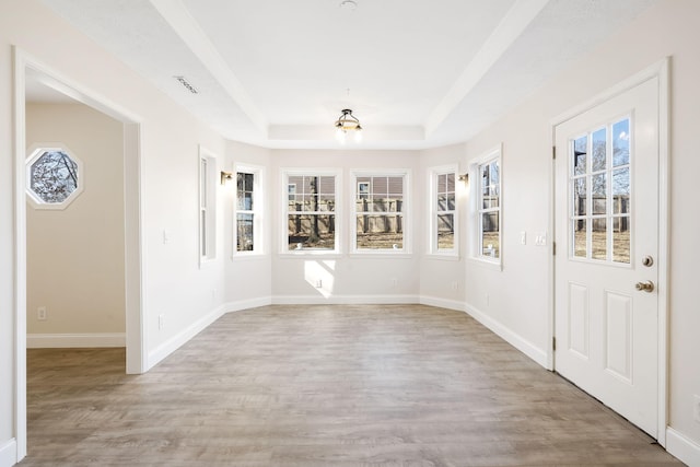 interior space with light hardwood / wood-style flooring and a raised ceiling