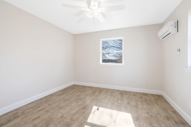 unfurnished room featuring a wall unit AC, light wood-type flooring, and ceiling fan