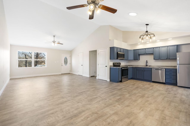 kitchen with pendant lighting, stainless steel appliances, sink, and light hardwood / wood-style flooring