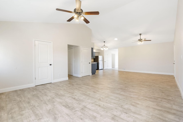 unfurnished living room with high vaulted ceiling, baseboards, light wood finished floors, and ceiling fan with notable chandelier