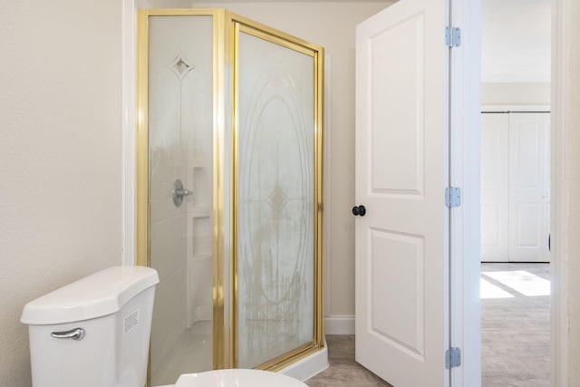 bathroom featuring walk in shower and toilet