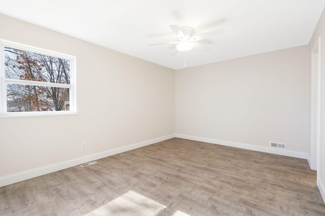 empty room with ceiling fan and light hardwood / wood-style floors