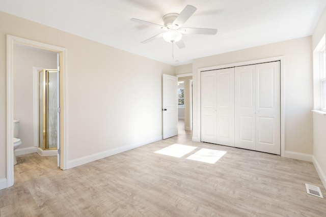 unfurnished bedroom featuring ensuite bathroom, ceiling fan, a closet, and light hardwood / wood-style flooring