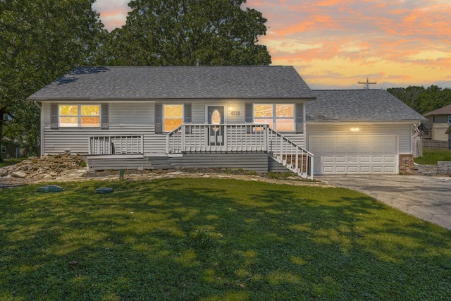 view of front of house featuring a garage, a porch, and a lawn