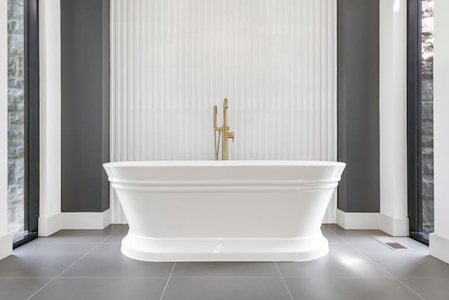 bathroom with tile patterned floors and a tub