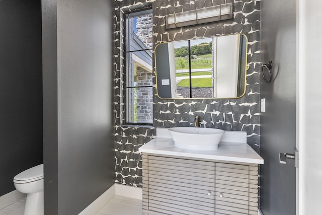 bathroom with tile patterned flooring, vanity, toilet, and tasteful backsplash