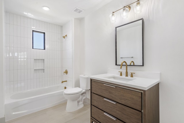 full bathroom featuring vanity, tiled shower / bath combo, and toilet