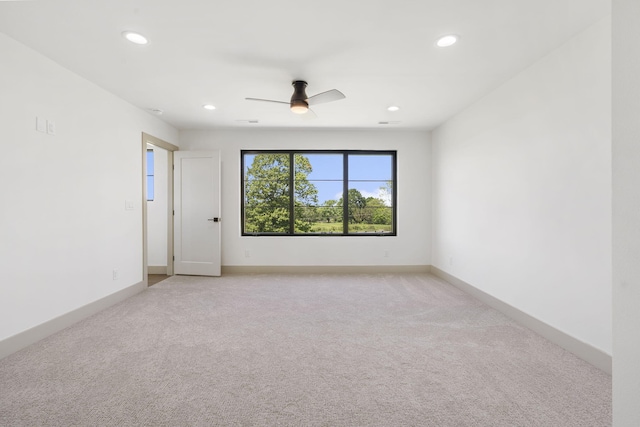 carpeted spare room featuring ceiling fan