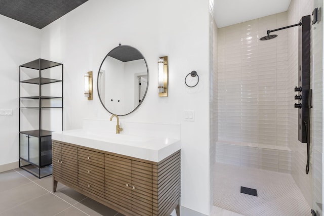 bathroom with tile patterned floors, vanity, and a tile shower