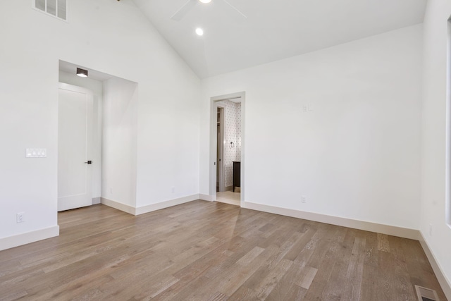 empty room with ceiling fan, high vaulted ceiling, and light hardwood / wood-style flooring