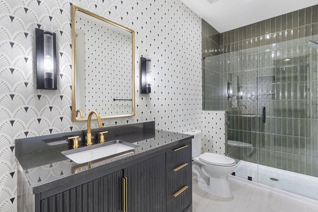 bathroom featuring vanity, a shower with shower door, and toilet