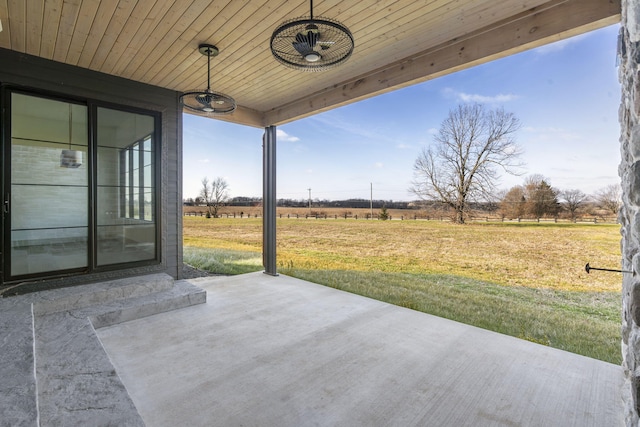 view of patio with ceiling fan and a rural view