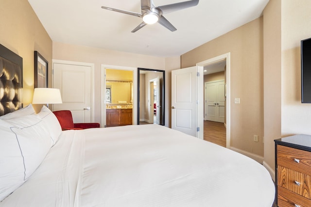 bedroom featuring ceiling fan, hardwood / wood-style floors, and connected bathroom