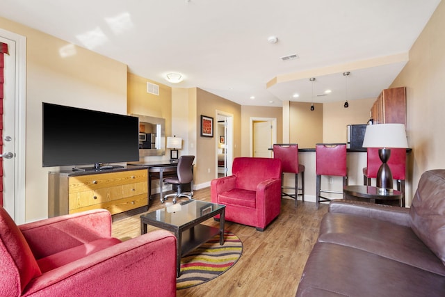 living room featuring light hardwood / wood-style flooring and built in desk