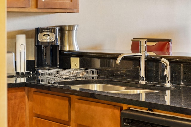 kitchen featuring dark stone counters and sink