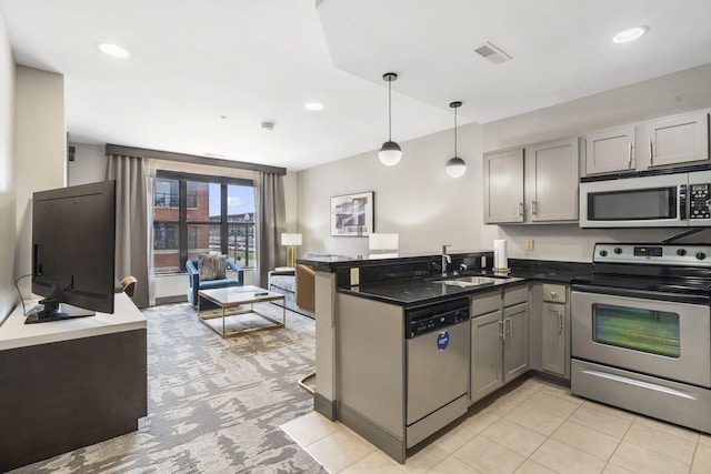 kitchen featuring sink, kitchen peninsula, decorative light fixtures, gray cabinets, and stainless steel appliances