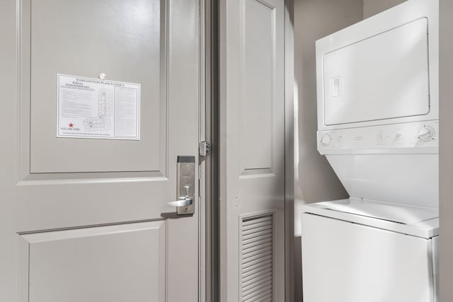 clothes washing area featuring stacked washer / dryer