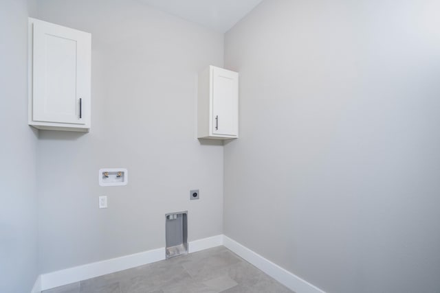 clothes washing area featuring electric dryer hookup, washer hookup, light tile patterned flooring, and cabinets