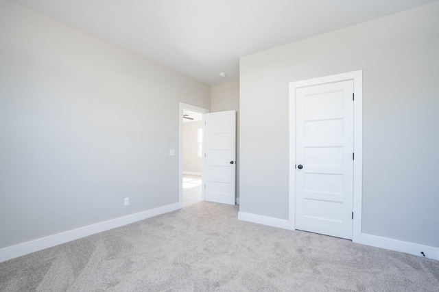 unfurnished bedroom featuring a closet and light colored carpet