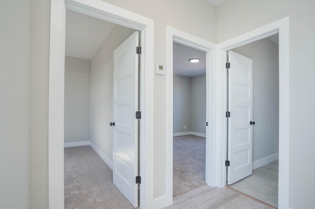 hall with light colored carpet