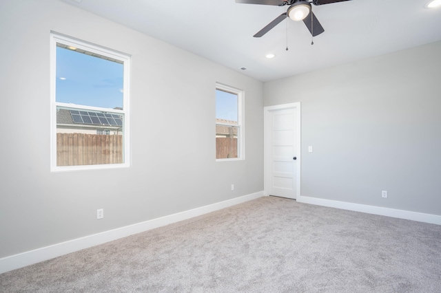 carpeted spare room with ceiling fan