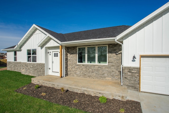 doorway to property with a garage and a lawn