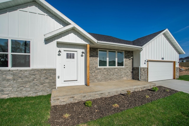 doorway to property featuring a garage and a lawn