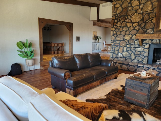 living room featuring beamed ceiling, a fireplace, and hardwood / wood-style flooring