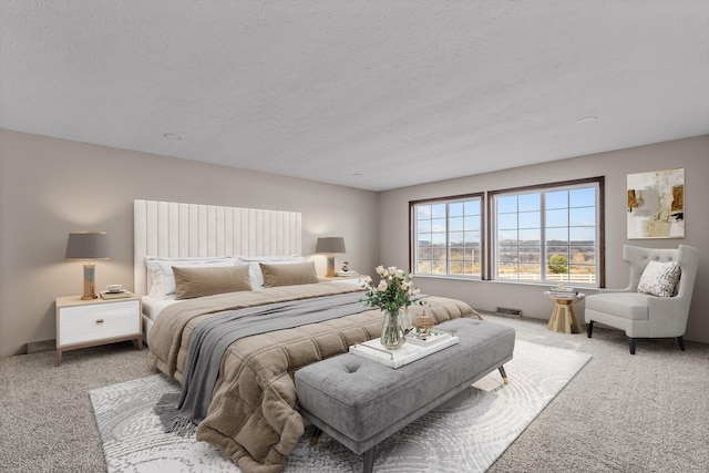 bedroom with light carpet and a textured ceiling