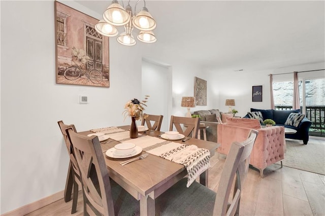 dining room featuring a notable chandelier and light hardwood / wood-style flooring