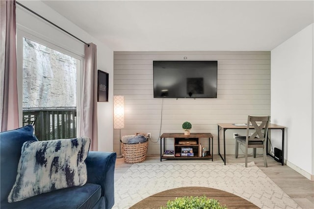 living room featuring wooden walls and light hardwood / wood-style flooring