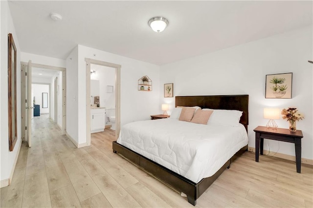 bedroom featuring light hardwood / wood-style floors and ensuite bath