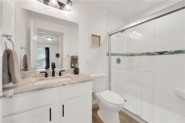 bathroom featuring an enclosed shower, wood-type flooring, vanity, and toilet