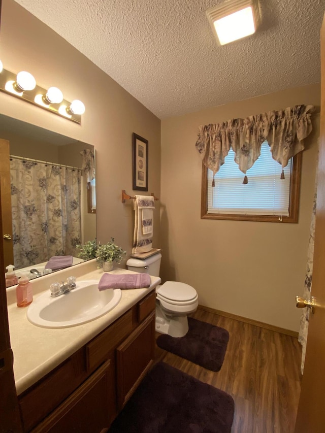 bathroom featuring wood finished floors, a textured ceiling, vanity, a shower with curtain, and toilet