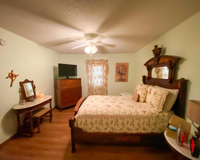 bedroom featuring wood finished floors, a ceiling fan, and baseboards