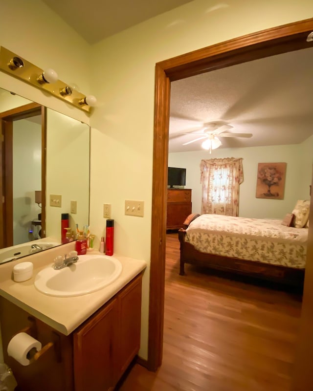 ensuite bathroom with a ceiling fan, vanity, wood finished floors, and ensuite bathroom