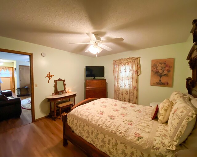 bedroom with wood finished floors, a textured ceiling, and a ceiling fan