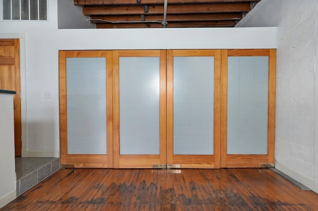 interior space with a high ceiling and dark wood-type flooring