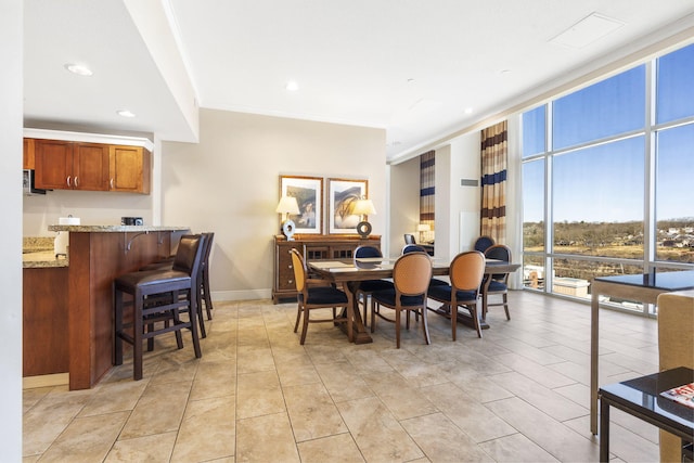 dining room with a wall of windows and light tile patterned floors