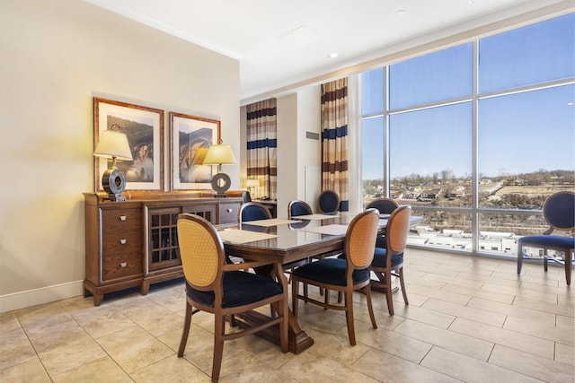 dining area with light tile patterned flooring, expansive windows, and ornamental molding