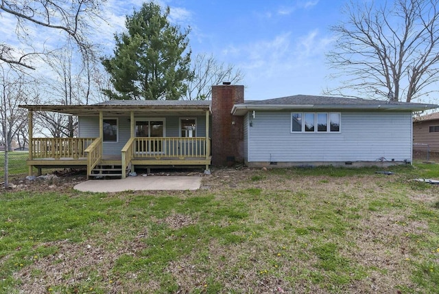 back of house with a wooden deck and a lawn