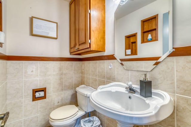 bathroom featuring tile walls, sink, and toilet